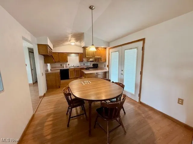 Dining room featuring vaulted ceiling and light wood-style flooring