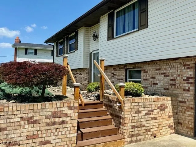 View of exterior entry featuring brick siding