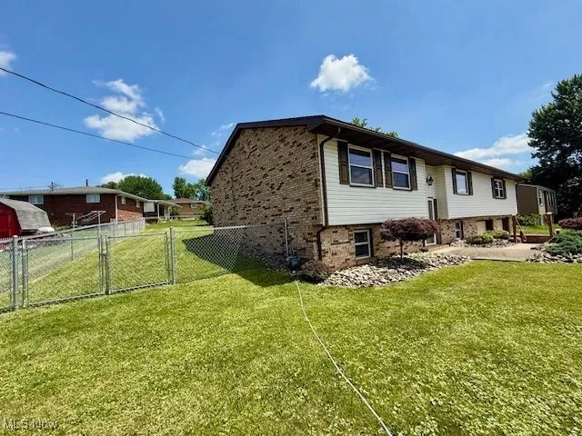 View of property exterior with brick siding and a gate