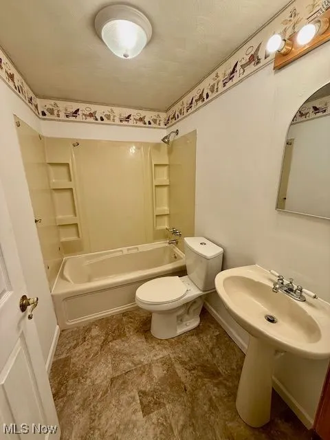 Full bathroom featuring toilet and tub / shower combination