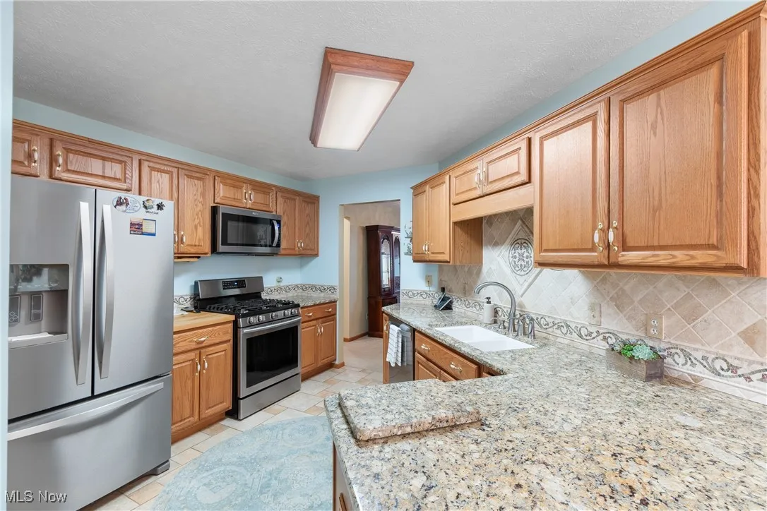 Kitchen boasts granite counters, stainless appliances, and large pantry.