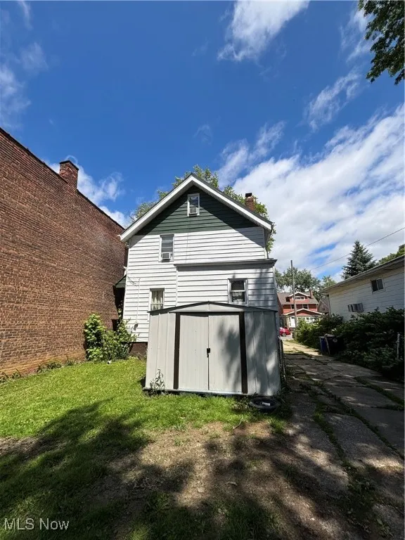 Back of house with a chimney and a yard