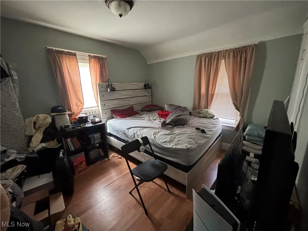 Bedroom featuring lofted ceiling and wood finished floors