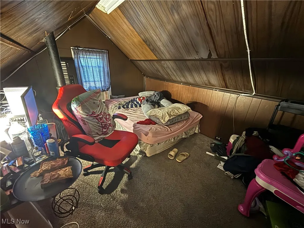 Carpeted bedroom featuring lofted ceiling