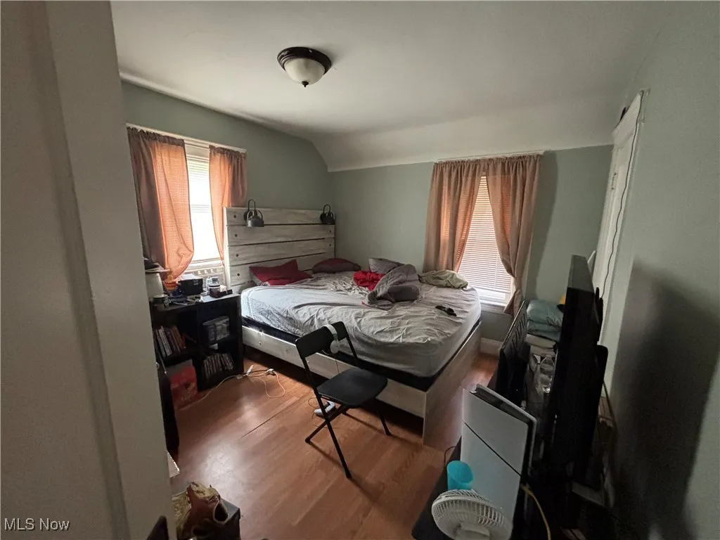 Bedroom featuring wood finished floors and lofted ceiling