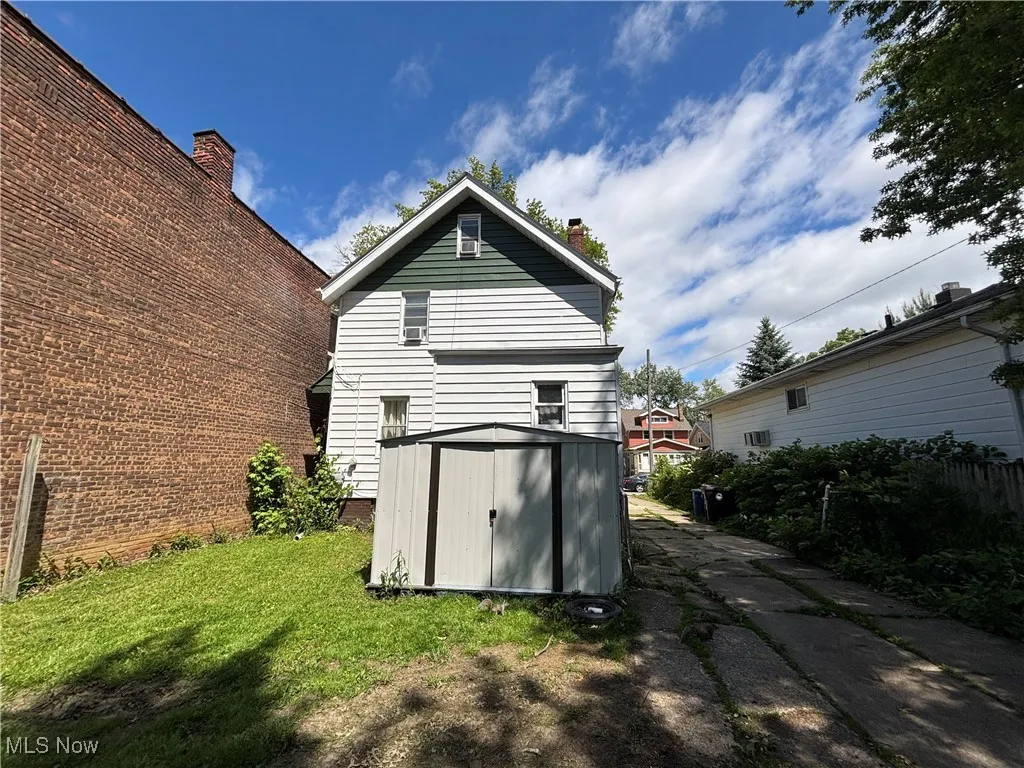 Rear view of property featuring a chimney and a yard