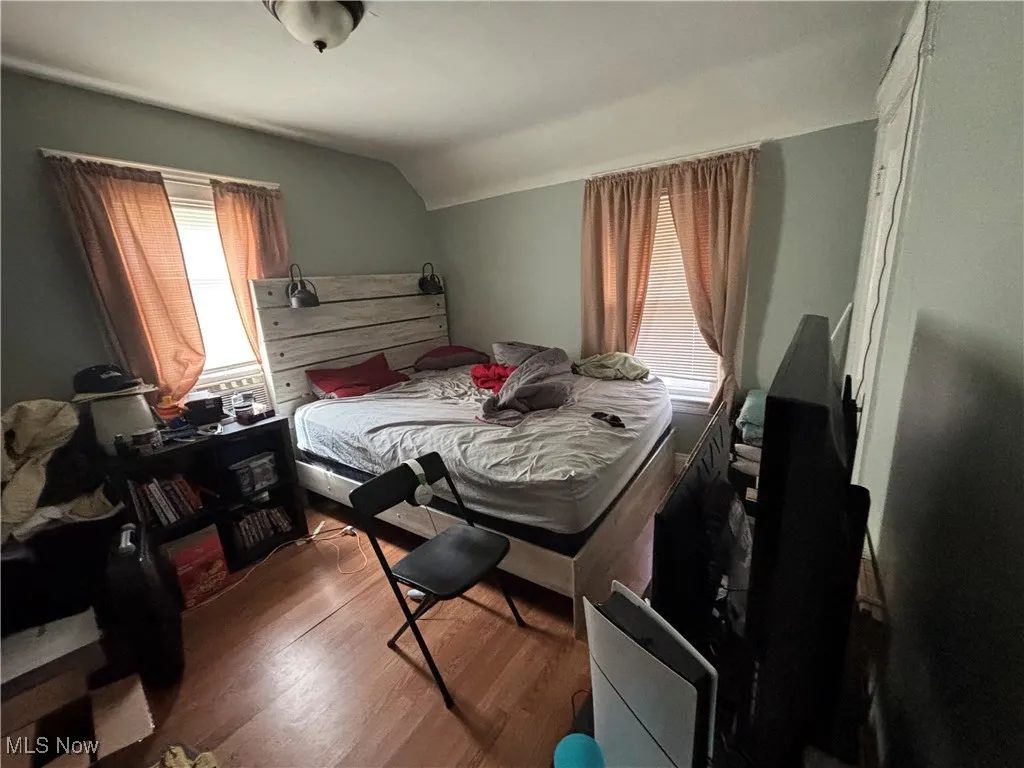 Bedroom with vaulted ceiling and wood finished floors
