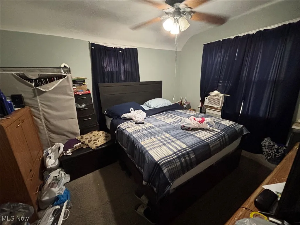 Bedroom featuring carpet flooring, cooling unit, and ceiling fan