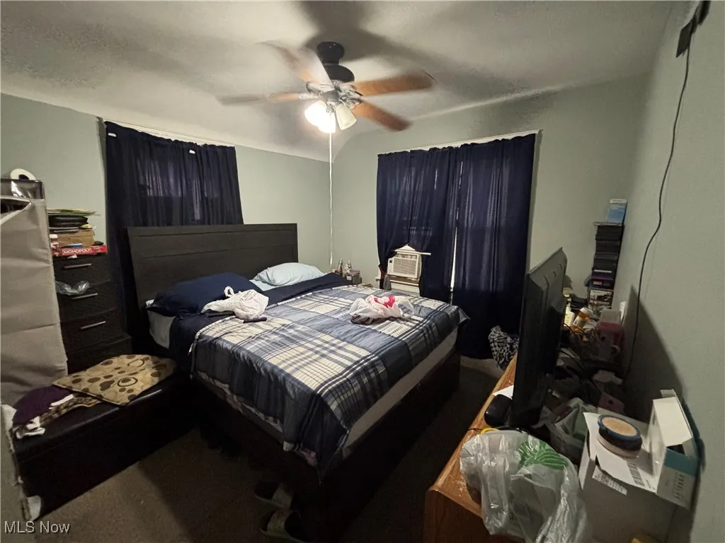 Bedroom featuring a ceiling fan, cooling unit, and carpet