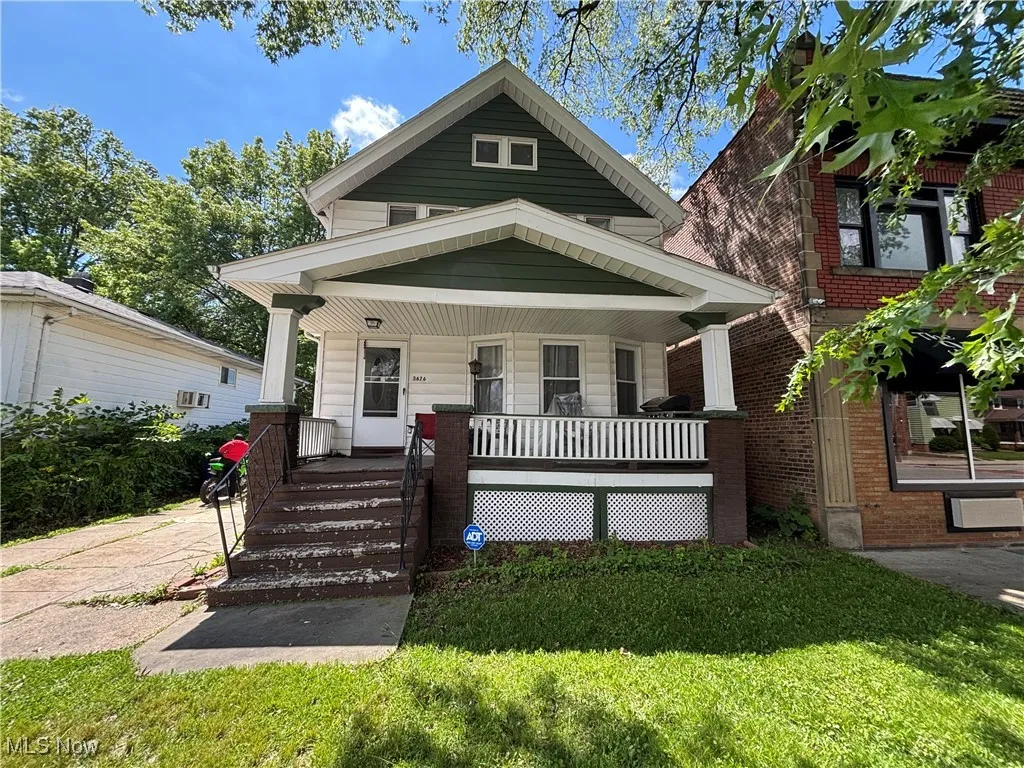 View of front facade with covered porch and a front lawn