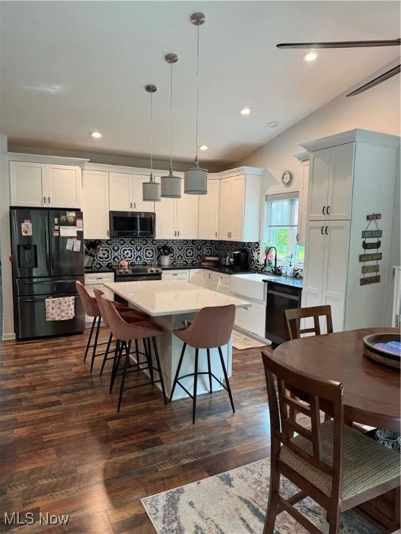 Kitchen with farmhouse sink, decorative backsplash, tall pantry cupboard, custom blinds and a kitchen island that seats 4. All appliances stay.