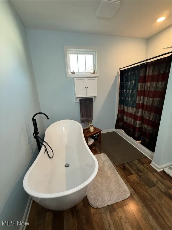 Elegance and serenity, wrapped up in a soaking tub!  Is that a wine bottle?