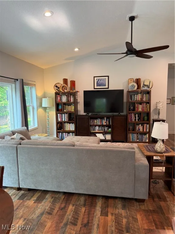 Great room featuring vaulted ceiling, dark wood-style floors, a ceiling fan, and recessed lighting is open to the kitchen, and surrounded by 2 patio doors and 2 windows overlooking the Cassell Reservation.