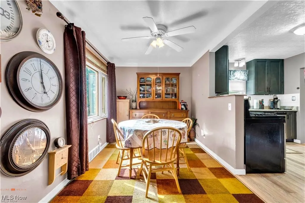 Dining space with ceiling fan, baseboards, and light floors