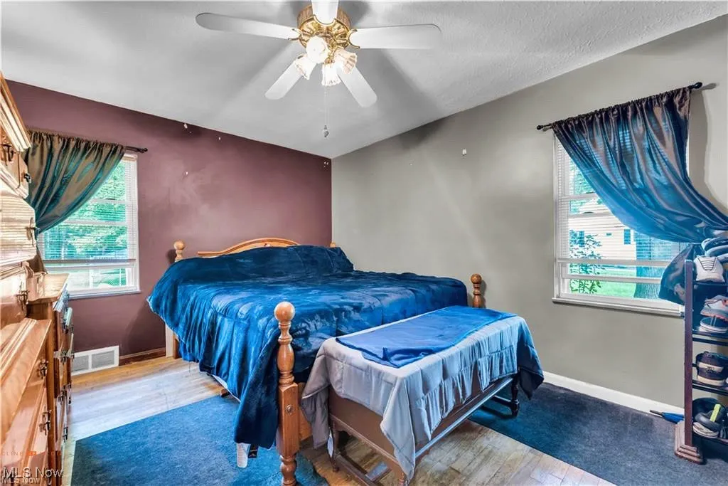 Bedroom with wood finished floors, baseboards, and ceiling fan
