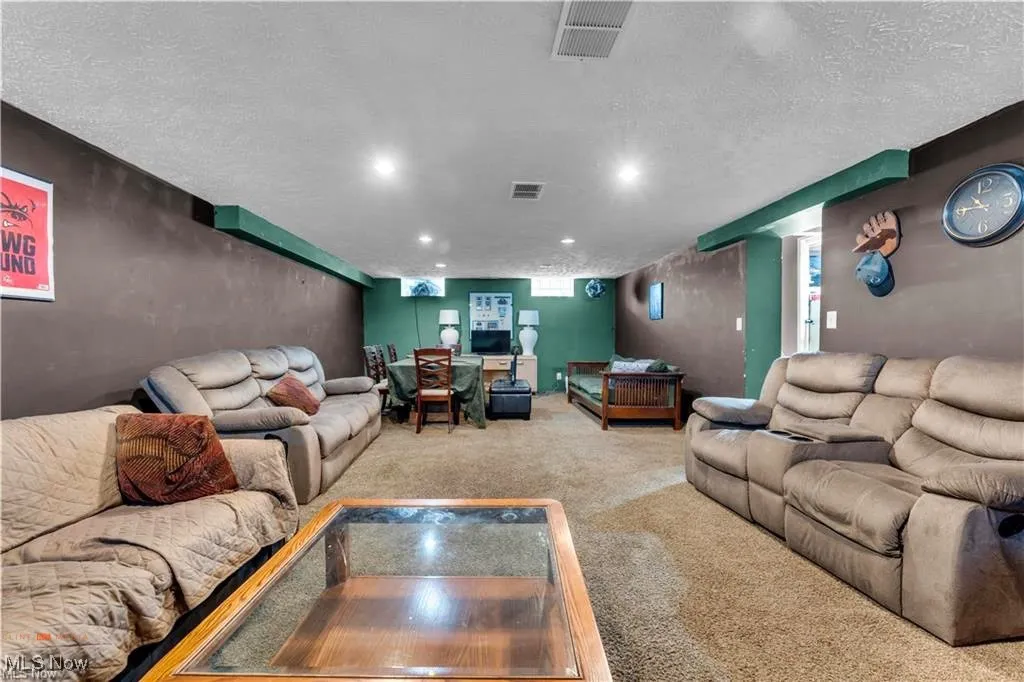 Living room with carpet floors, a textured ceiling, and recessed lighting