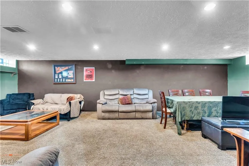 Living room with carpet flooring, a textured ceiling, and recessed lighting