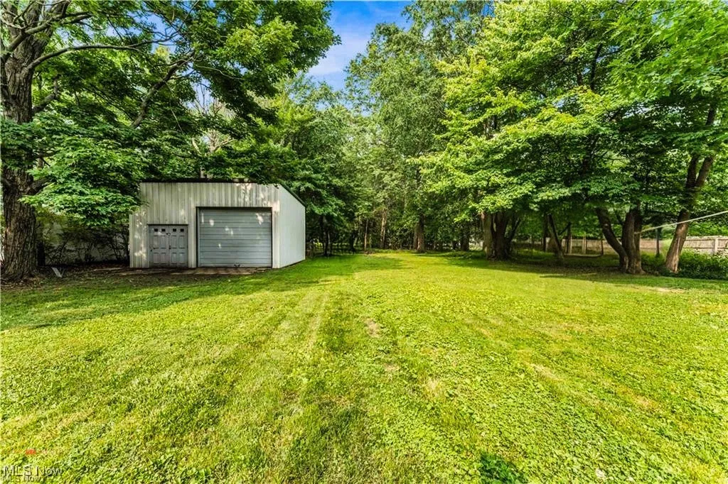View of grassy yard featuring an outbuilding