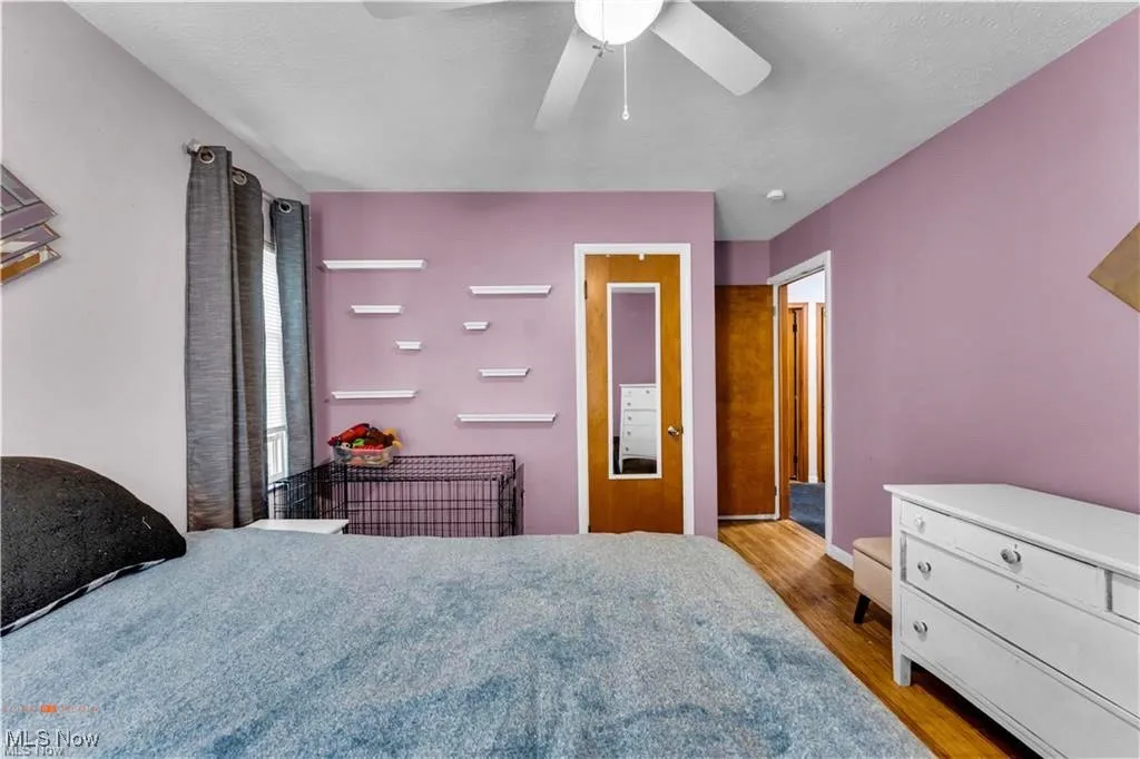 Bedroom with wood finished floors, ceiling fan, and baseboards