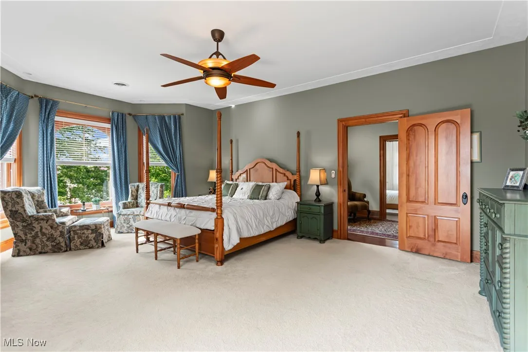 Carpeted bedroom with a ceiling fan