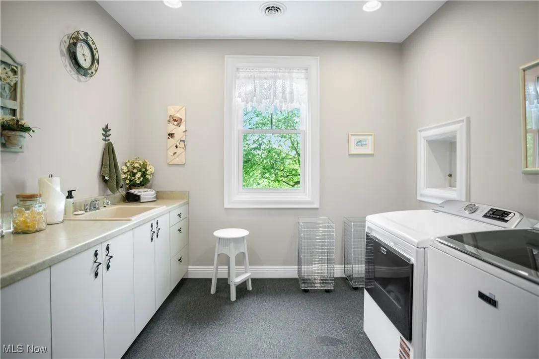 Laundry room featuring washer and dryer, cabinet space, dark colored carpet, baseboards, and recessed lighting