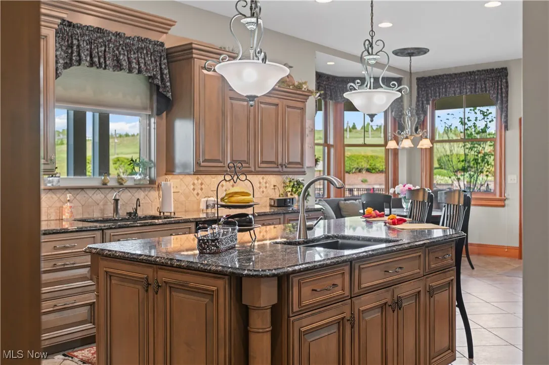 Kitchen featuring a sink, healthy amount of natural light, an island with sink, and recessed lighting
