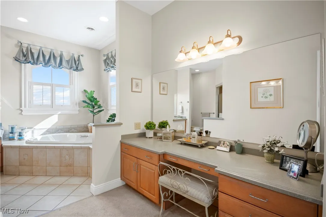 Bathroom with a garden tub, vanity, and tile patterned floors