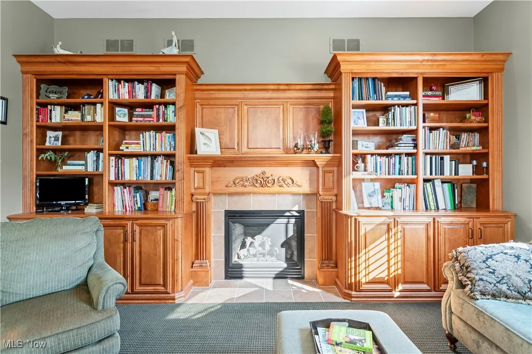 Carpeted living area with a tiled fireplace and tile patterned floors