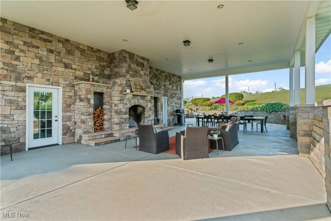 View of patio featuring an outdoor stone fireplace