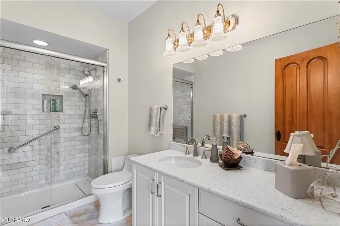 Full bathroom with vanity, a shower stall, toilet, and tile patterned floors