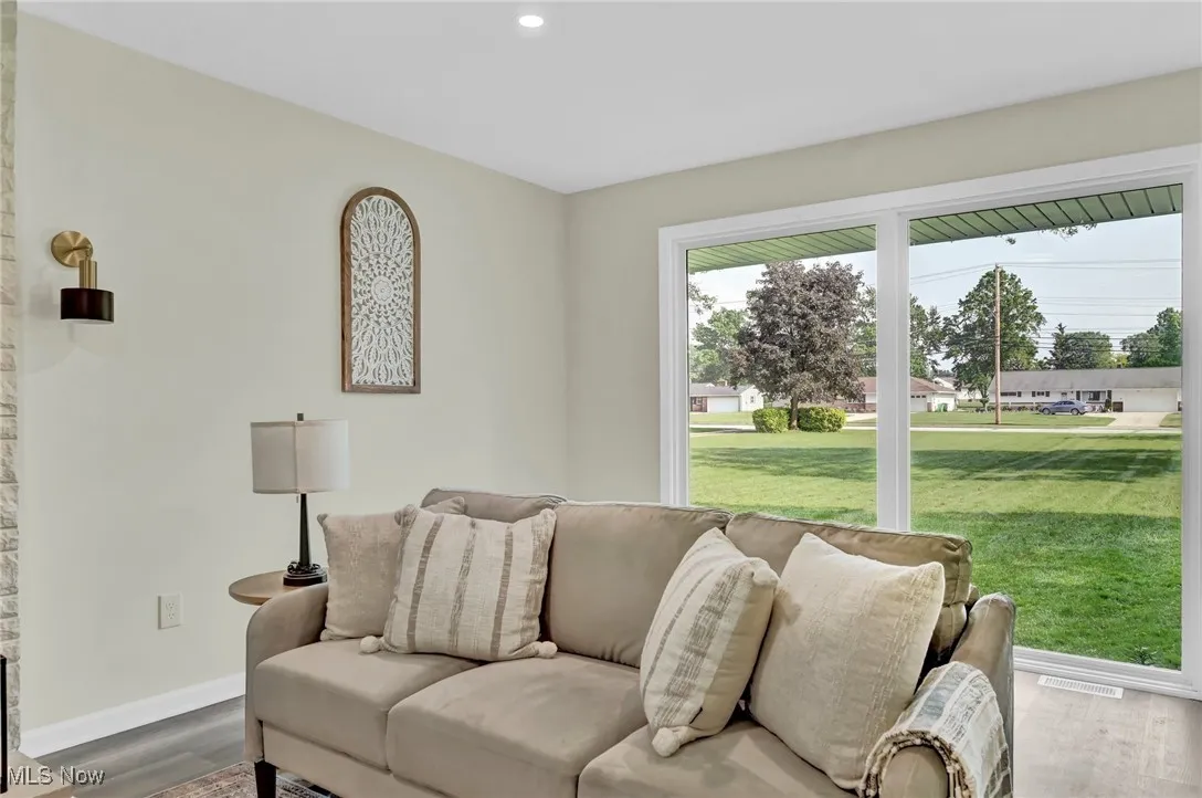 Living room with wood finished floors, baseboards, and recessed lighting