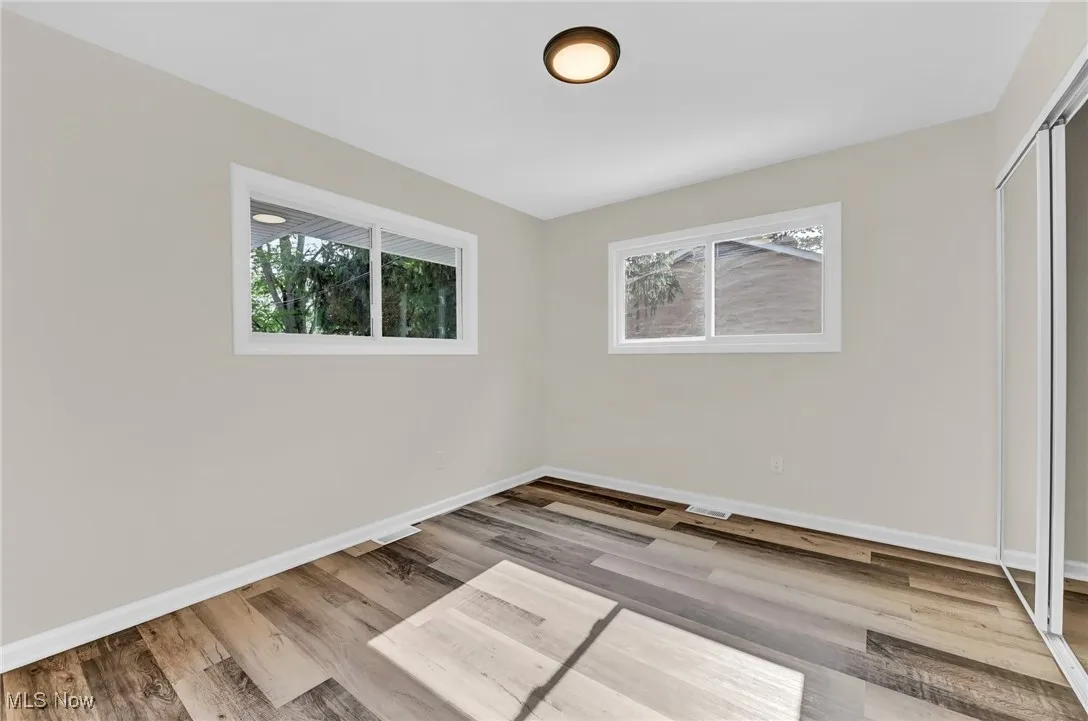 Unfurnished bedroom with baseboards, wood finished floors, and a closet