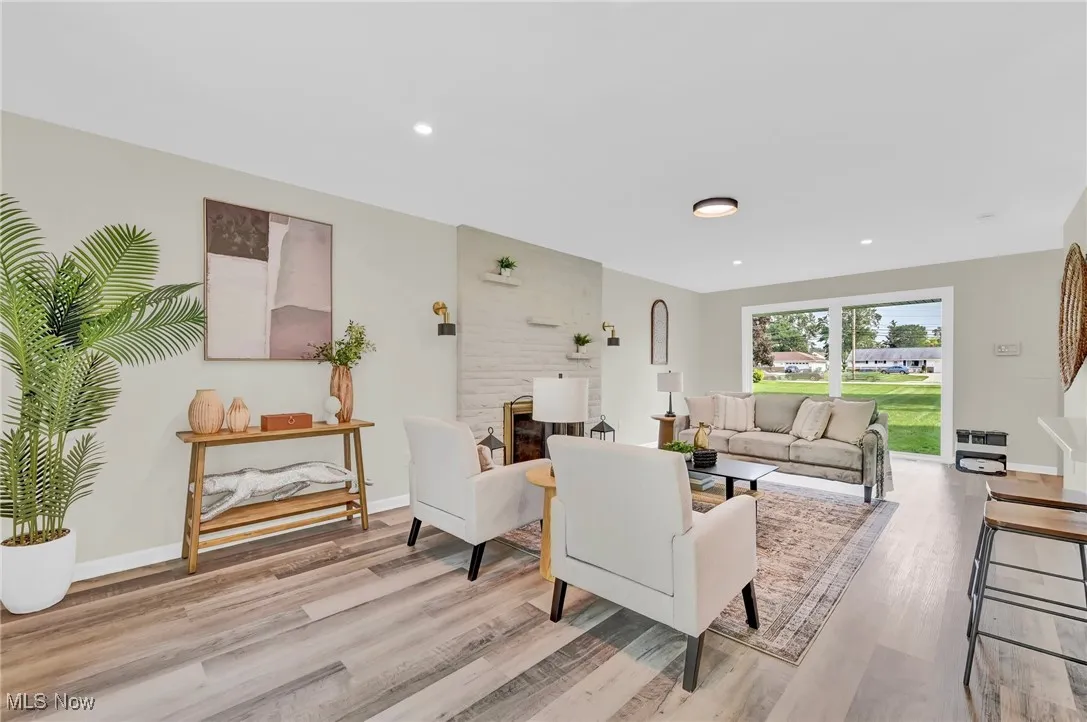 Living room with light wood-style floors, baseboards, and recessed lighting