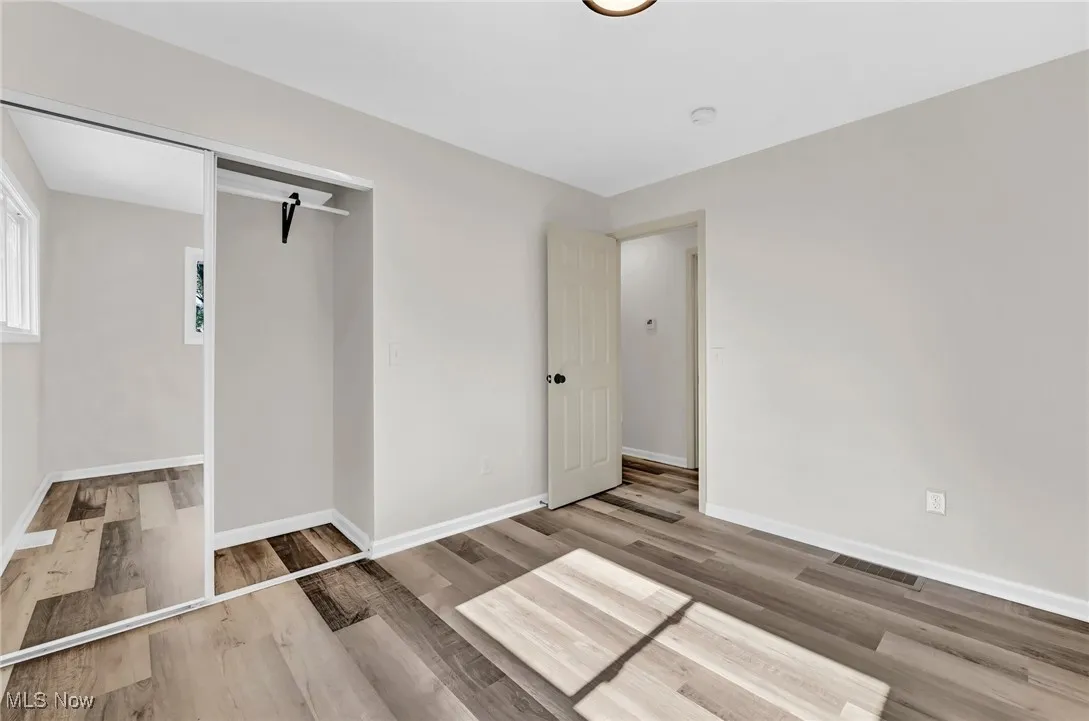 Unfurnished bedroom featuring wood finished floors and baseboards