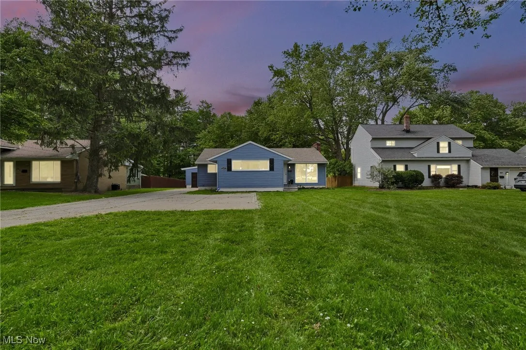 View of front of property with driveway, a lawn, and a chimney