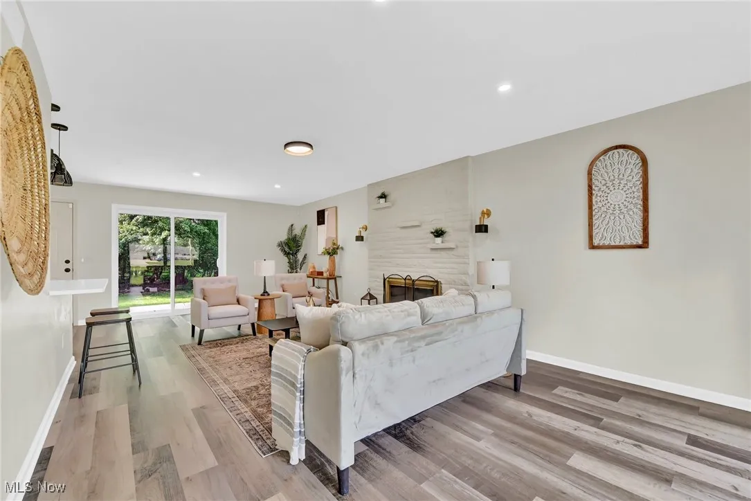 Living area with wood finished floors, baseboards, and recessed lighting