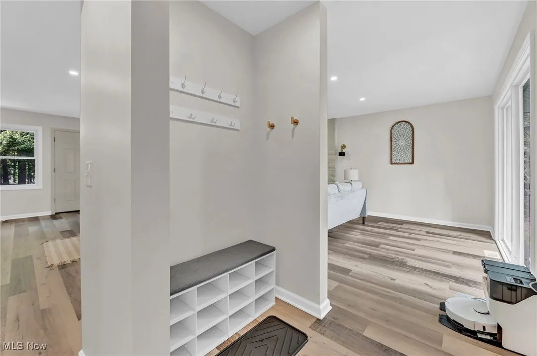 Hall with wood finished floors, baseboards, and recessed lighting