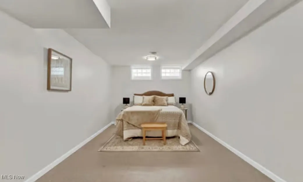 Bedroom featuring baseboards and finished concrete flooring
