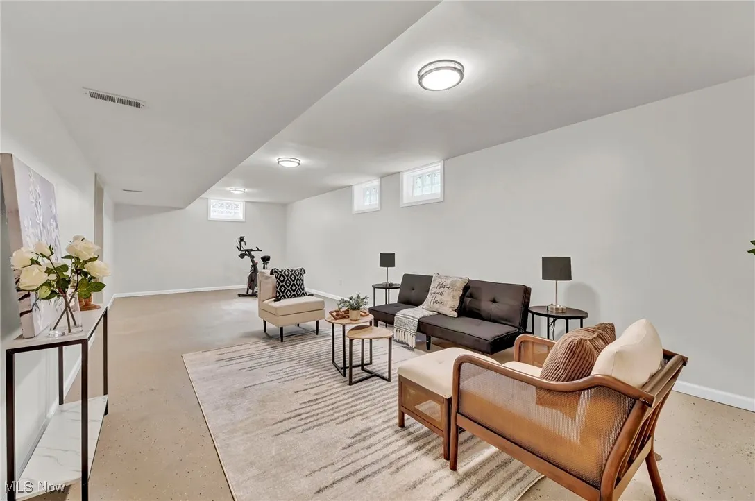 Living room with baseboards, concrete floors, and plenty of natural light