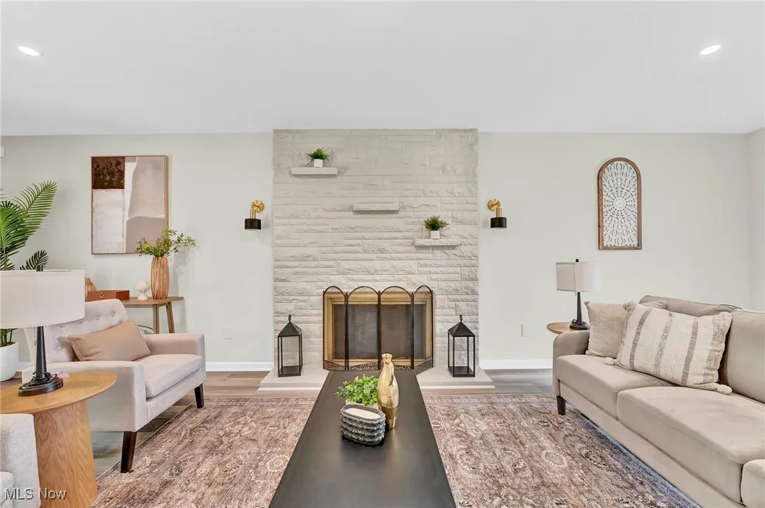 Living room featuring wood finished floors, a fireplace, recessed lighting, and baseboards