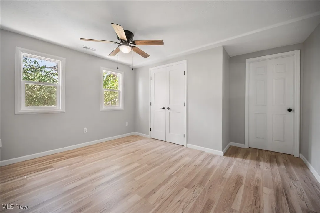 Unfurnished bedroom featuring baseboards, light wood finished floors, a closet, and ceiling fan