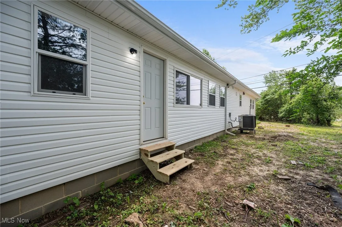 View of home's exterior with entry steps and central air condition unit