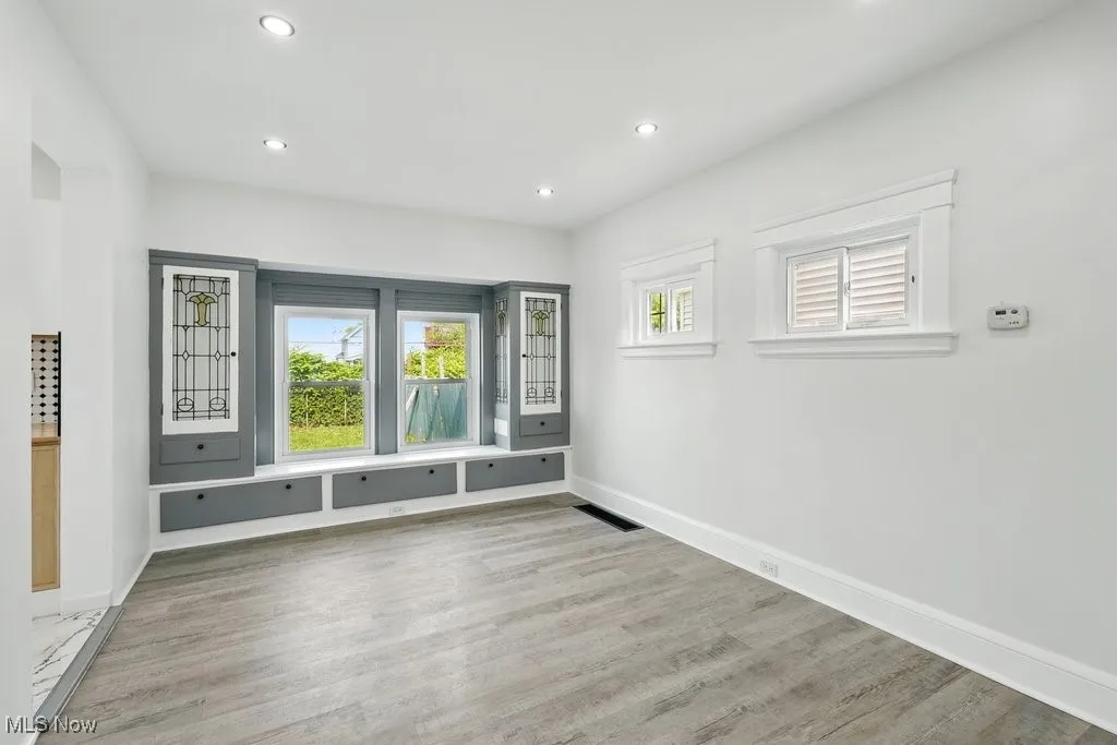 Unfurnished room featuring wood finished floors, baseboards, and recessed lighting