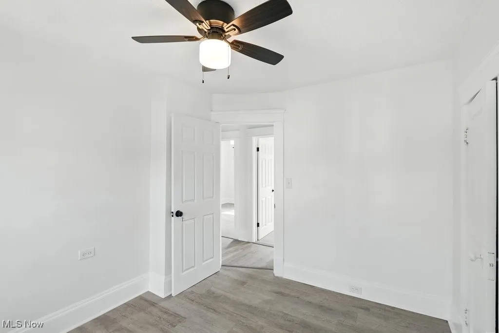 Unfurnished room with baseboards, a ceiling fan, and wood finished floors