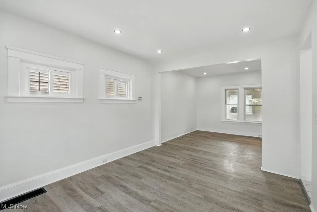 Unfurnished room with healthy amount of natural light, wood finished floors, recessed lighting, and baseboards