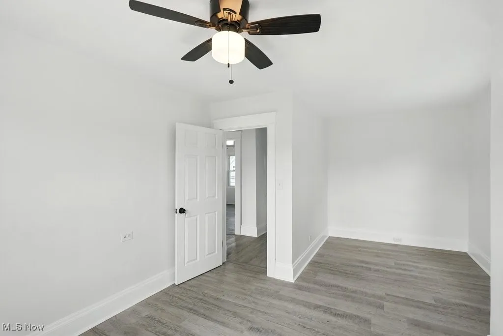 Spare room with baseboards, a ceiling fan, and wood finished floors