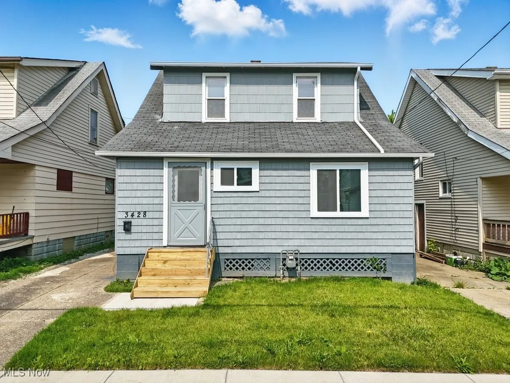 Back of property featuring a yard and roof with shingles