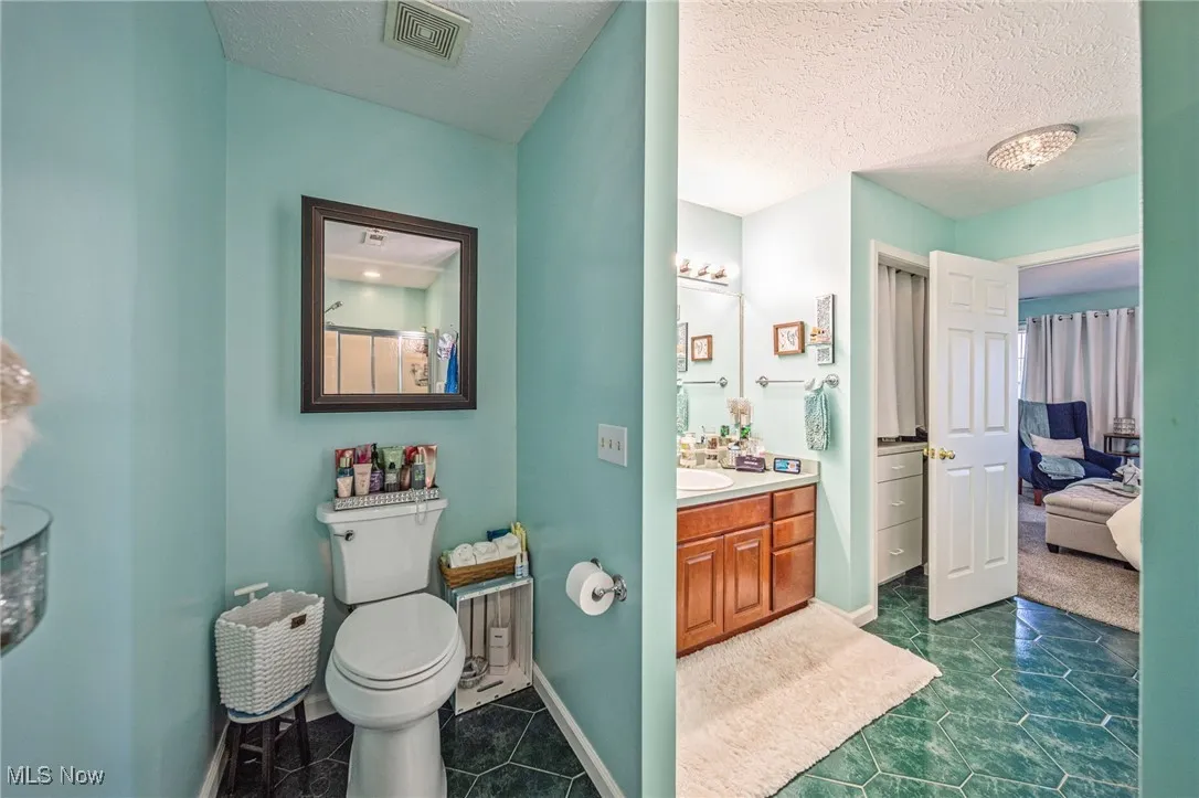 Huge full primary en suite bathroom with private toilet area!  Notice the additional storage behind the bathroom door!