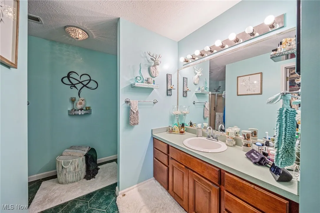 Primary full bathroom with ceramic tiled flooring, large vanity with mirror, separate shower & toilet areas!