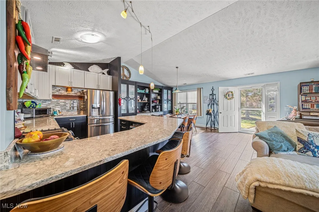High end ceramic tiled flooring with wood grain, custom desigened Cambria countertops surround this gorgeous kitchen!